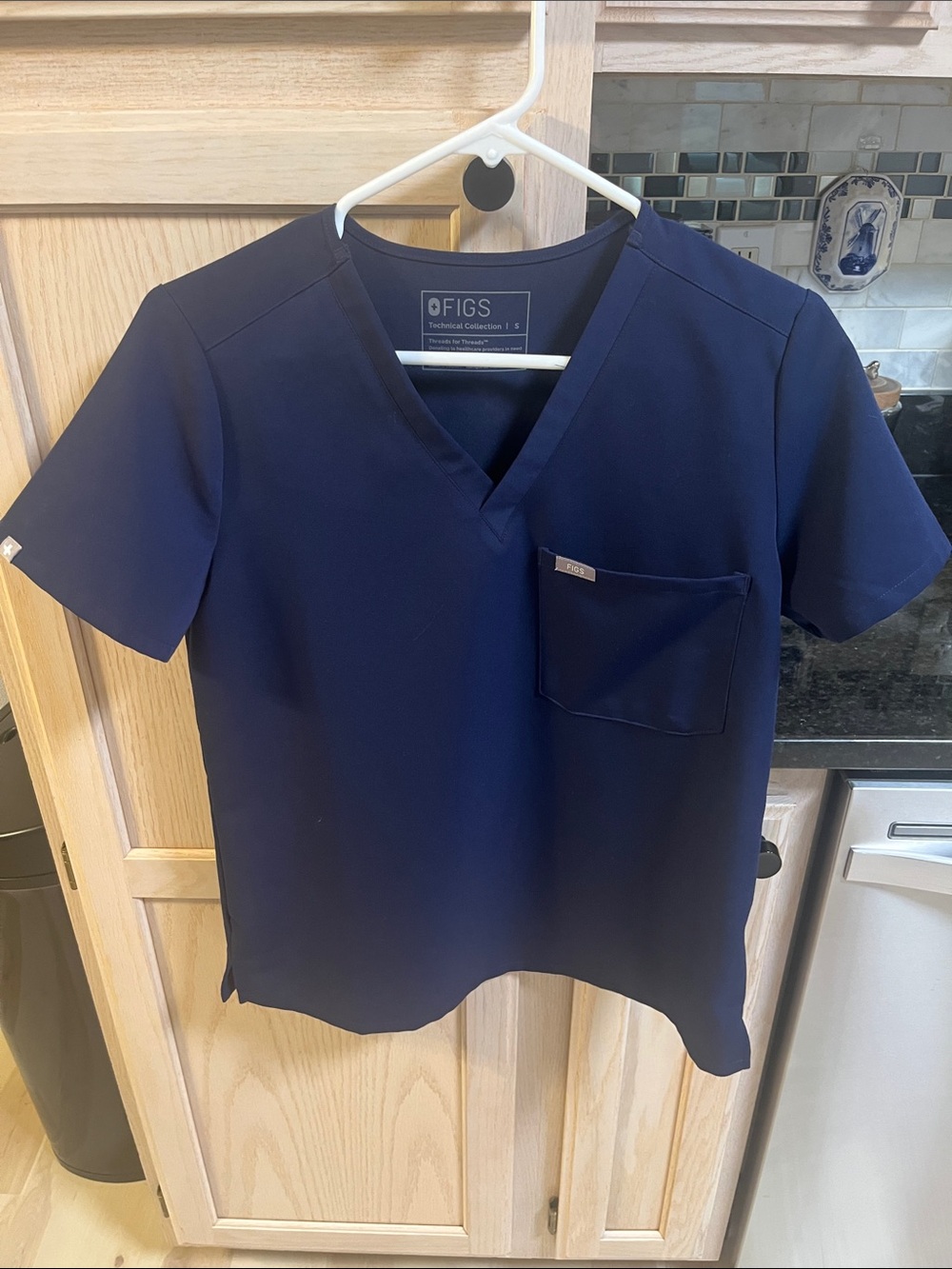 FIGS Women’s Short Sleeve V-Neck Scrub Top in Navy Blue and jogger scrub pants.